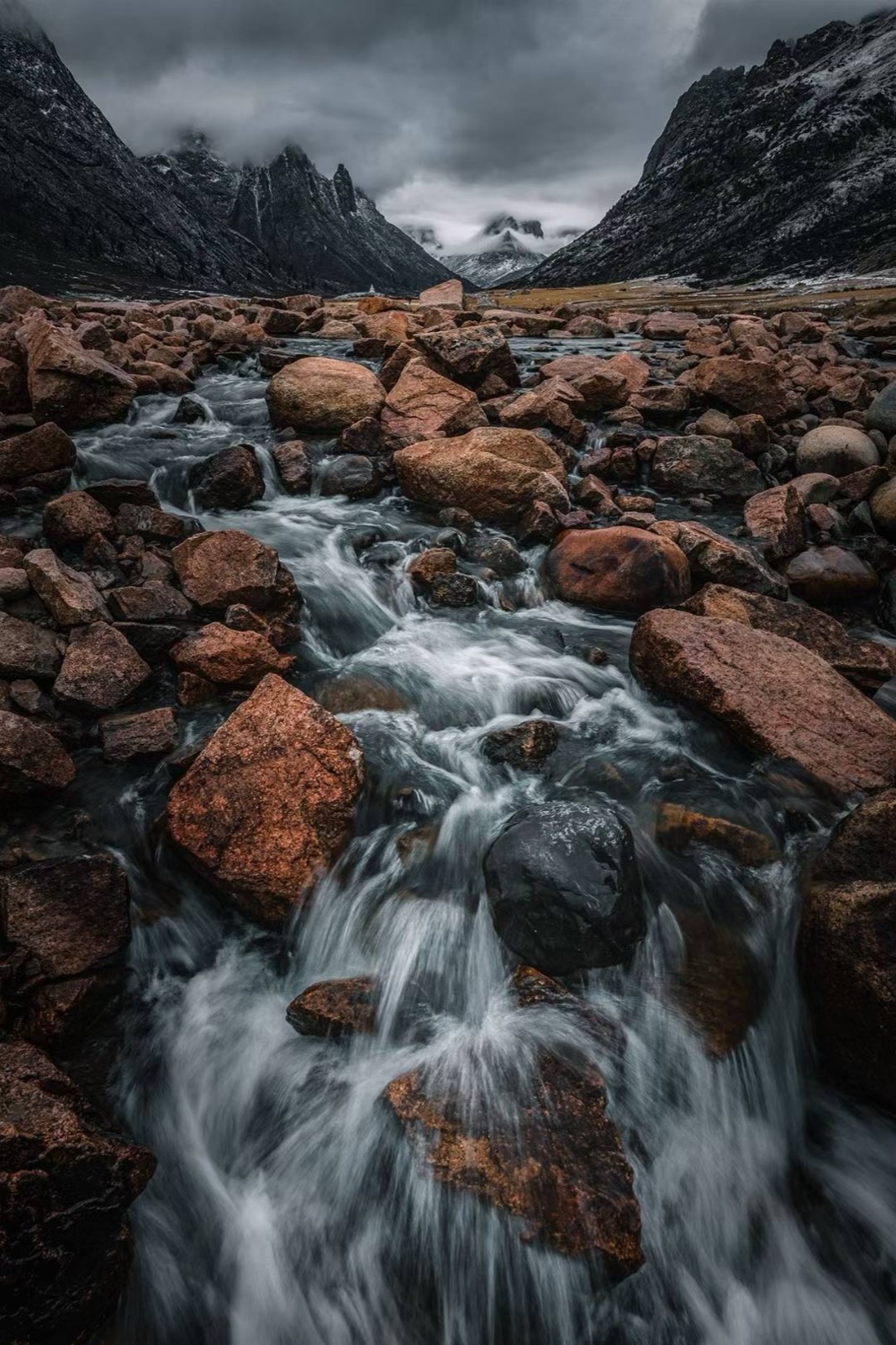 Boulder stream under moody peaks
